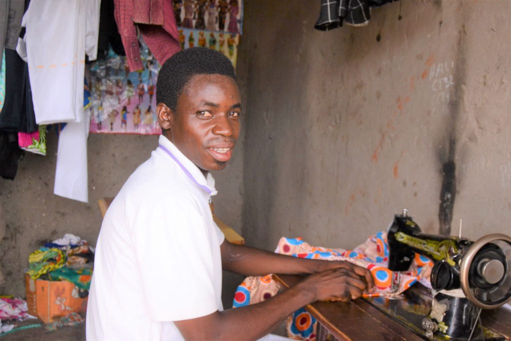 David dans son atelier de couture qu'il a ouvert grâce aux crédits reçus dans le groupe de microcrédit communautaire.