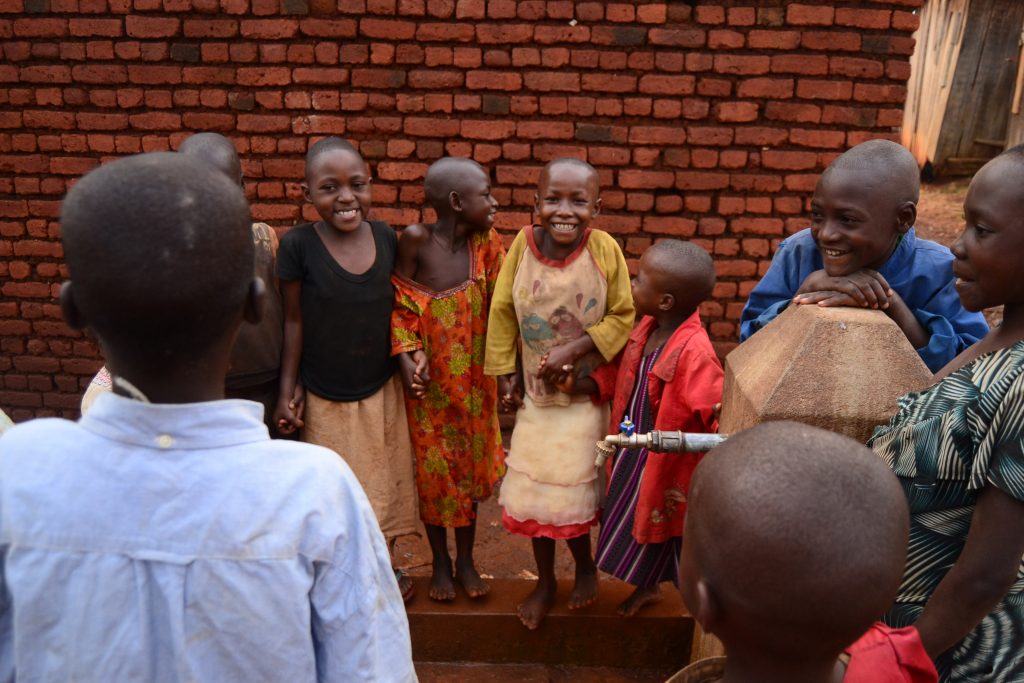 A Rukanda, des enfants en train de jouer autour d'une borne fontaine